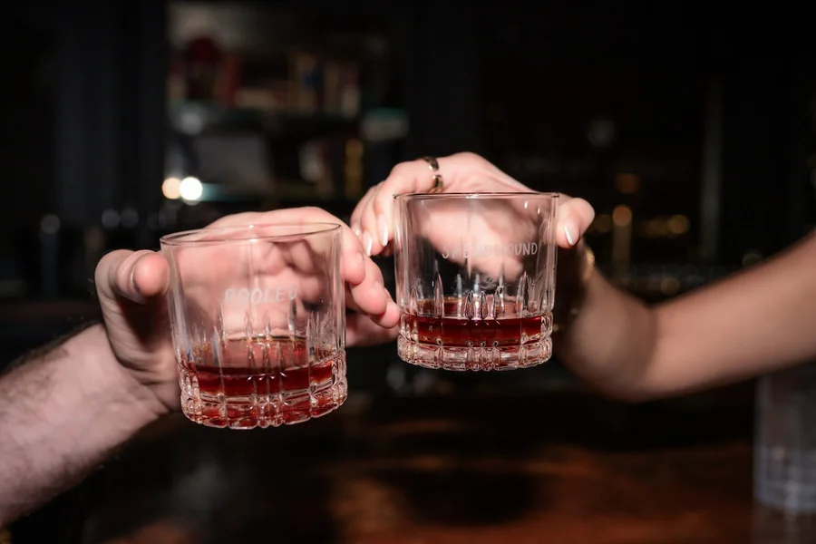 Guests raising whiskey glasses in a toast
