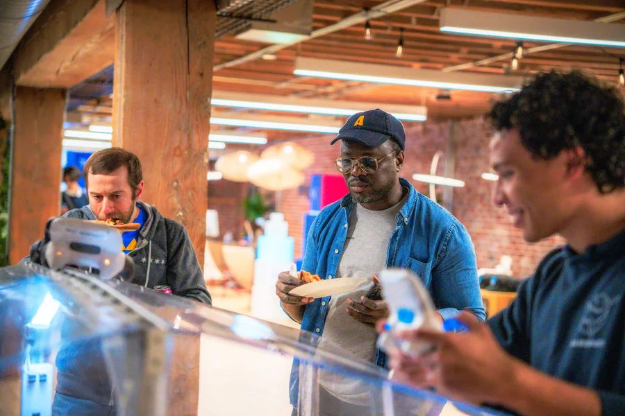 Three attendees talking around a table at an evening event