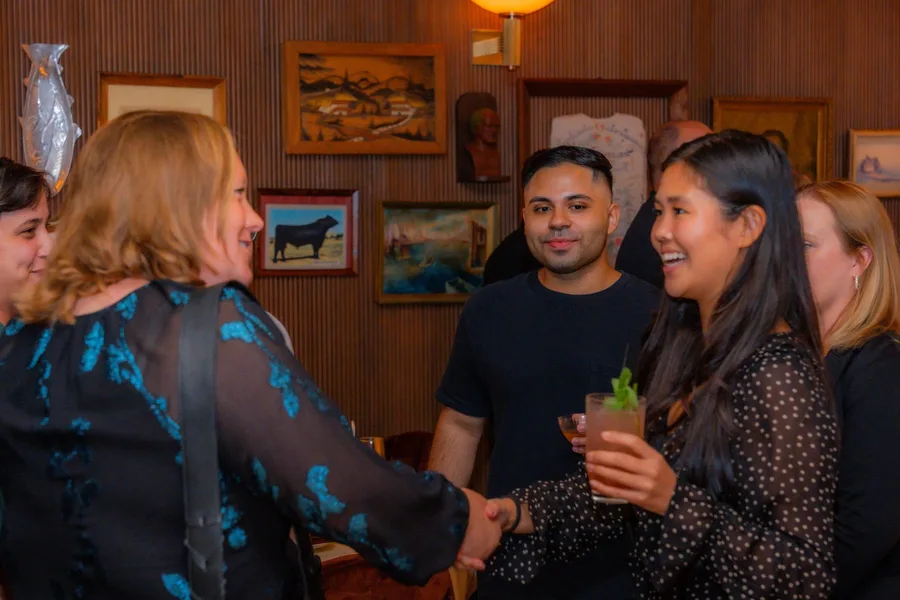 Three guests in conversation over dinner