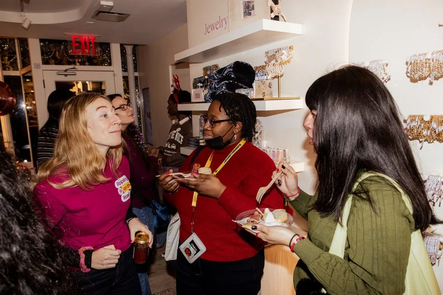 Three guests smiling and talking over drinks at a Rippling event