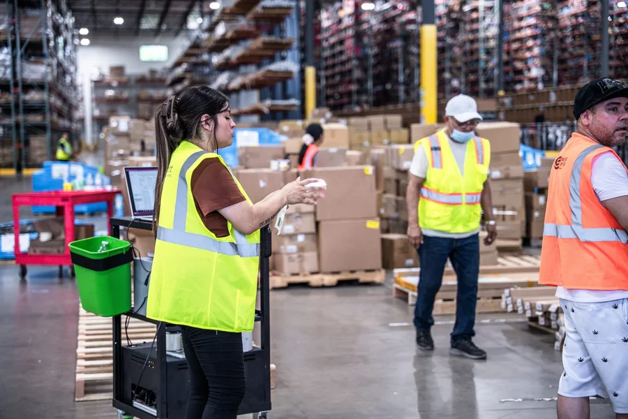 Warehouse staff meeting on the floor in high-visibility clothing