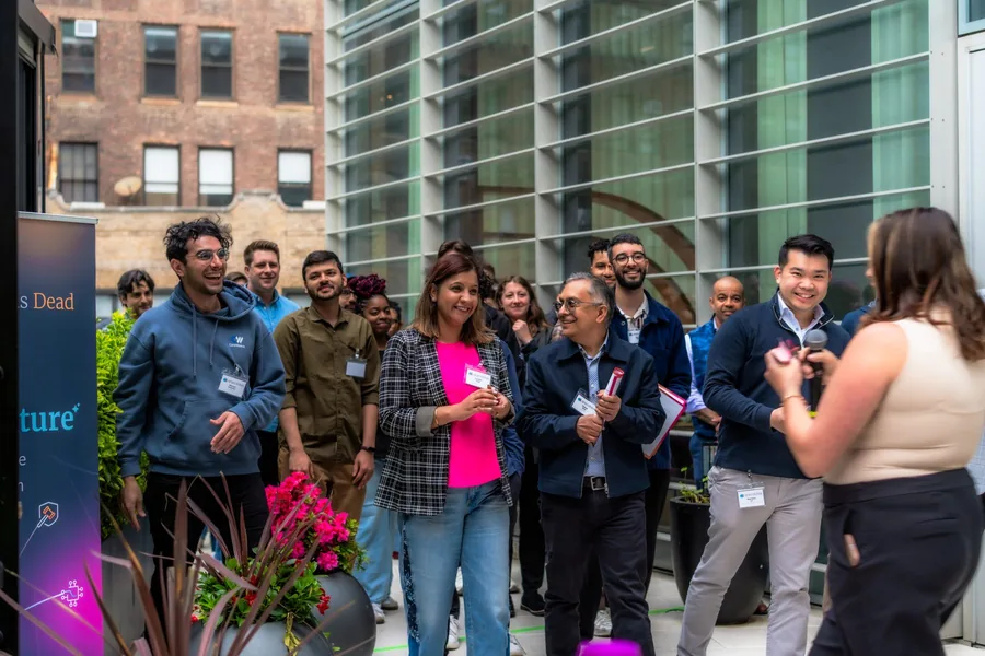 Guests smiling during a rooftop presentation at an Anecdotes event