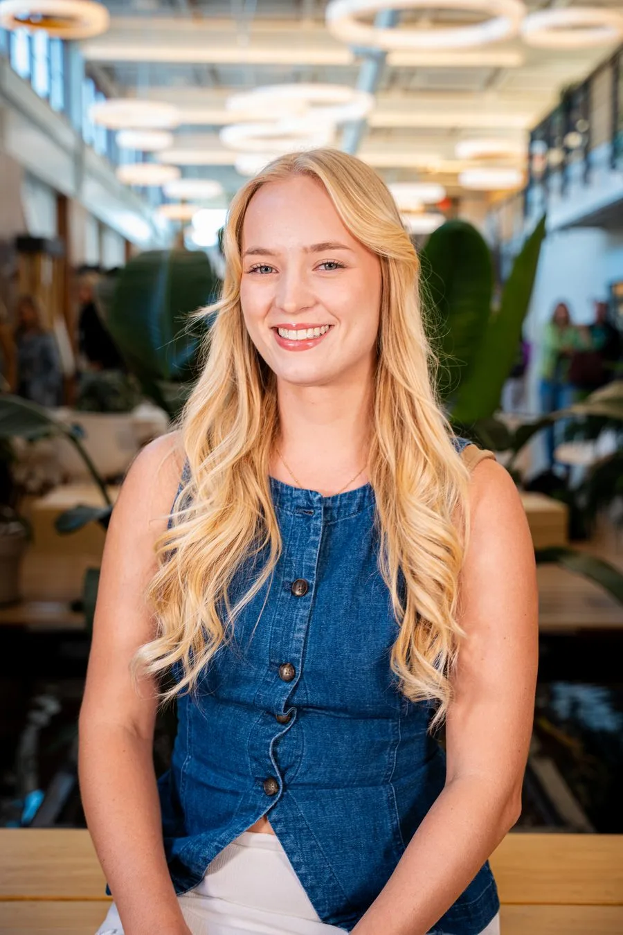 A guest in a blue vest smiling for an event portrait