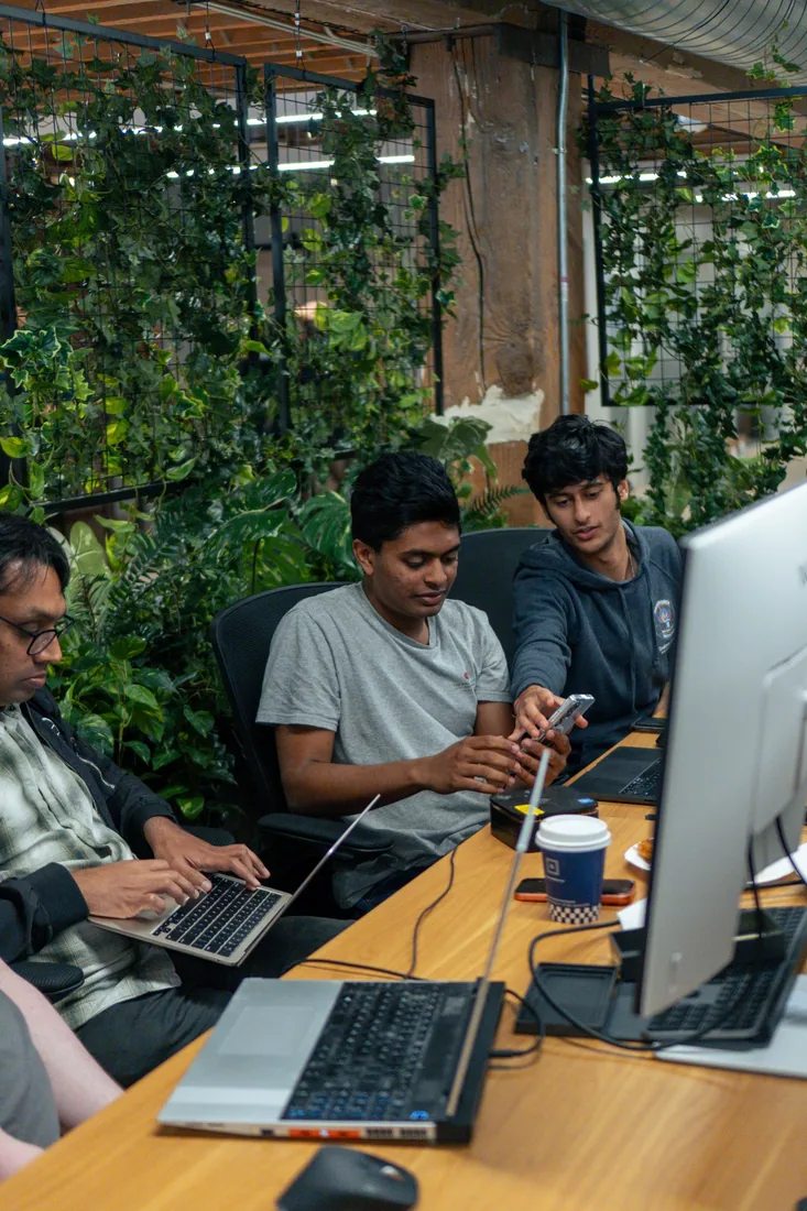 Hackathon participants working together at laptops