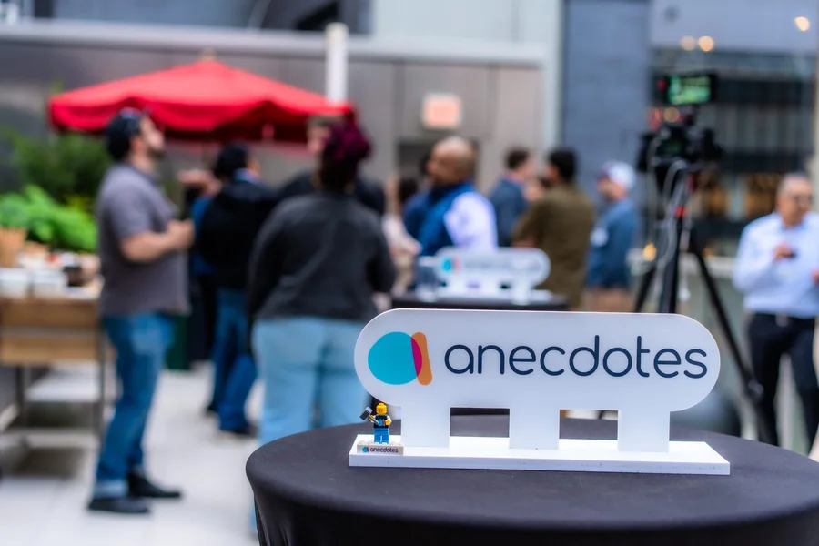 An Anecdotes table sign with rooftop guests in the background