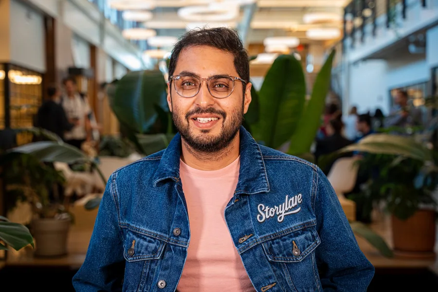 A guest in a denim jacket smiling for an event portrait