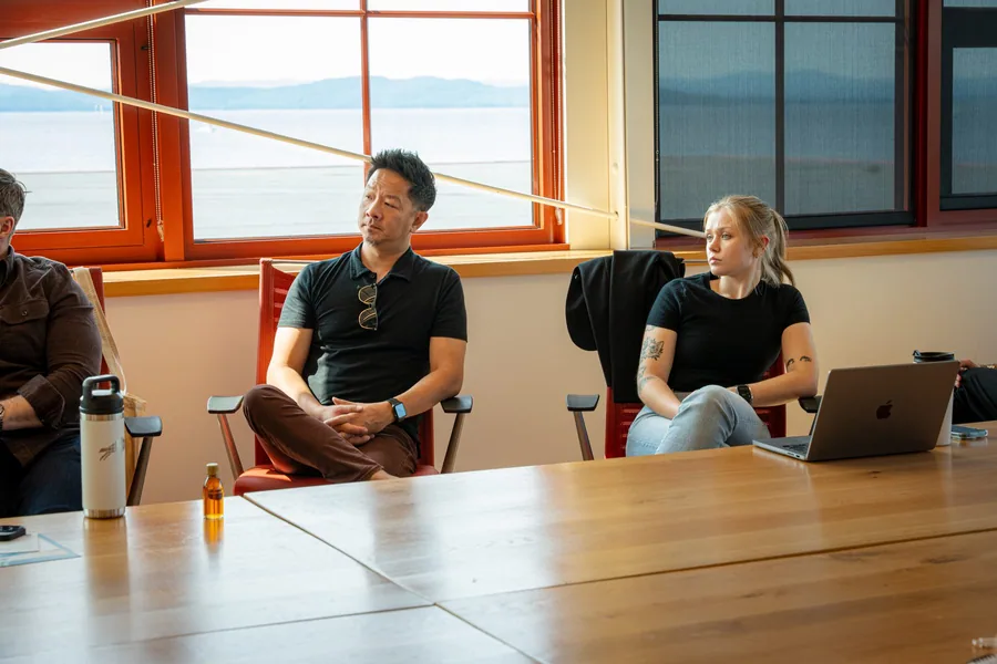 Two attendees listening during a sunlit roundtable discussion