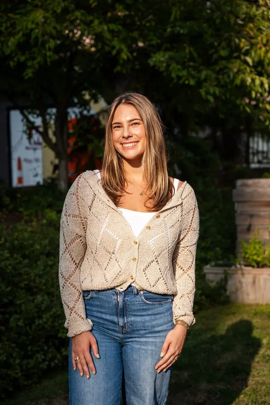 A guest smiling for a full-length outdoor event portrait