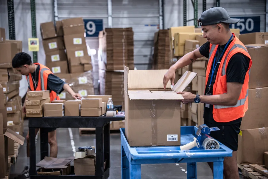 Warehouse team packing orders at a fulfillment station