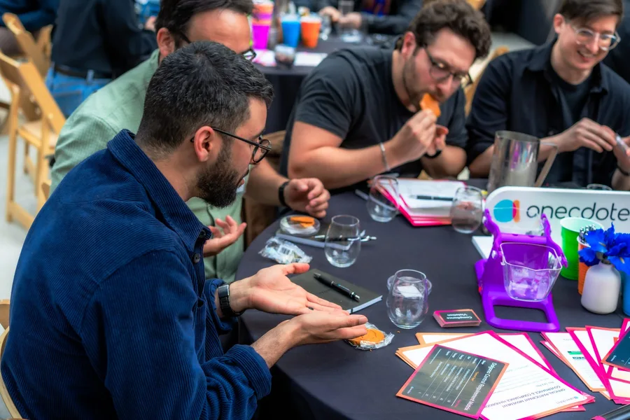 Guests taking part in a tabletop activity beside Anecdotes branding