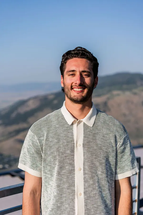 A Highline attendee smiling for an outdoor mountain portrait