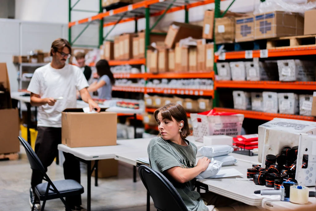 Warehouse staff working at packing stations at Revamp Fulfillment