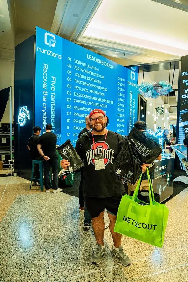 An attendee posing beside the runZero Prism of Truth activation