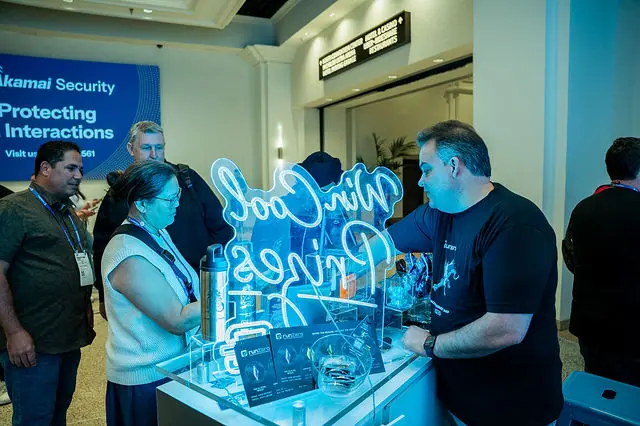 A runZero team member demonstrating the booth experience to a guest