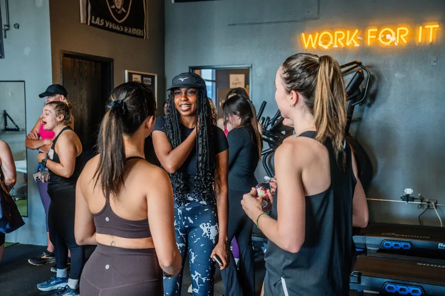Participants talking together in a gym after the Seemplicity workout