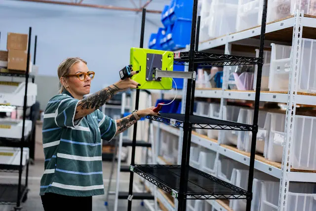 A fulfillment employee scanning inventory on warehouse shelving