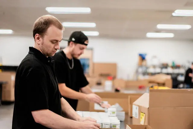 Uptime Fulfillment staff packing products at a workbench